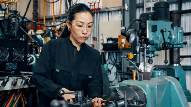 Жена за машином у фабрици