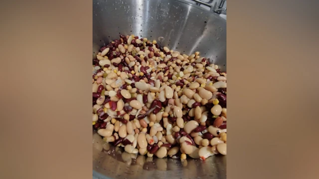 Un colador lleno de diferentes tipos de frijoles.