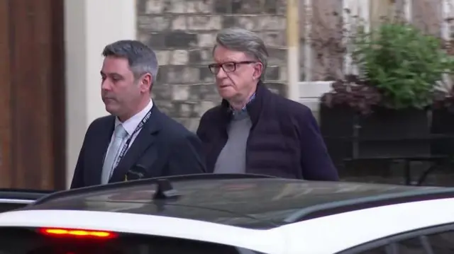 Un funcionario de Policía de paisano escolta a Mandelson tras ser detenido en su casa.