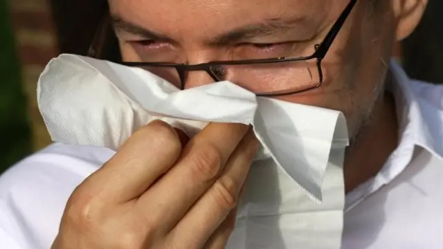 टिसू पेपरले नाक पुछ्दै एक व्यक्ति (साङ्केतिक तस्बिर)