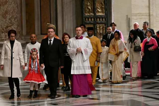 Os primeiros peregrinos passam pela porta santa durante cerimônia que marcou a abertura do Jubileuapp de fazer aposta de futebol2025, na Basílicaapp de fazer aposta de futebolSão Pedro