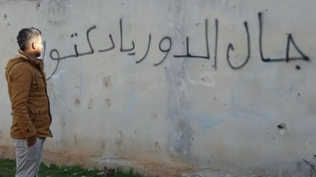 A young man looking at a graffiti