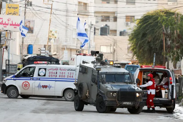 سيارات الإسعاف ومركبة عسكرية إسرائيلية خلال مداهمة إسرائيلية في جنين بالضفة الغربية المحتلة، 21 يناير/كانون الثاني 2025