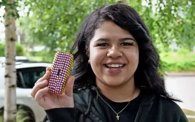 Grace a décidé de décorer son téléphone portable de base avec des boules de plastique colorées.