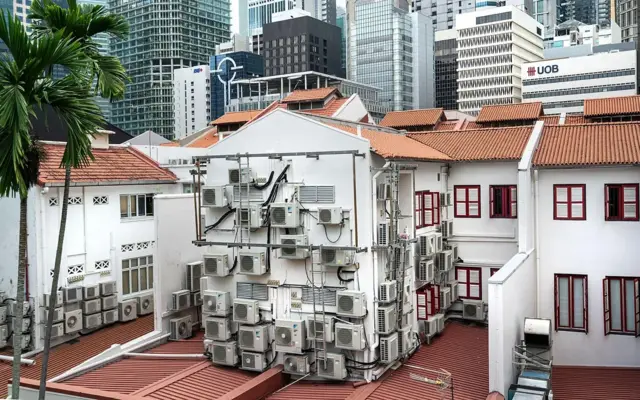 แม้ว่าจะมีพื้นที่สีเขียวและร่มเงา แต่สิงคโปร์ยังคงต้องพึ่งพาเครื่องปรับอากาศอย่างมากเพื่อให้บ้านเรือนและสำนักงานเย็นสบาย