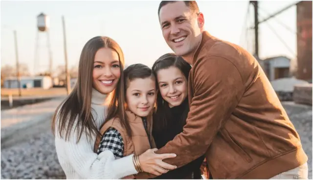 ስቴፋኒ ሃንራሃን (በስተግራ) ከሁለት ልጆቿ (መካከል) እና ከባለቤቷ ጋር (በስተቀኝ) ተቃቅፈው