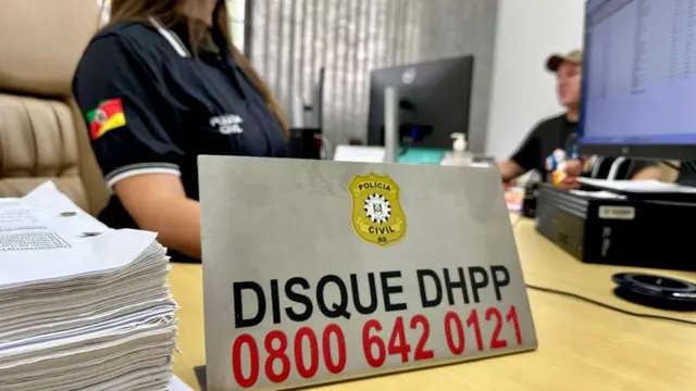 Mulher atráscomo entrar na roleta brasileiraplacacomo entrar na roleta brasileiraescritório que diz: Disque DHPP