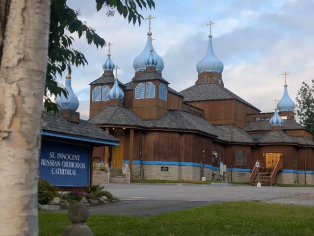 храм св. Иннокентия - деревянная темно-коричневая церковь с голубыми куполами