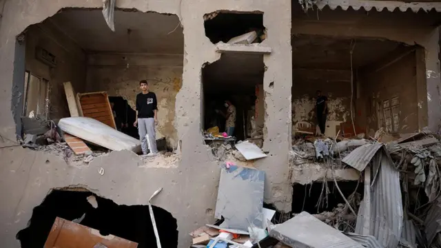 イスラエルの攻撃で破壊された集合住宅の中に立つ男性(11日、ベイルート)