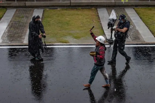 A rain shaman walking with incense bowl in the rain, ahead of the MotoGP Grand Prix in Lombok, Indonesia