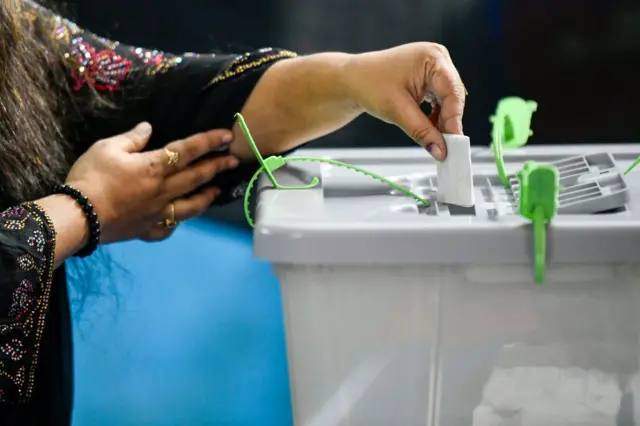 ভোটের বাক্সে ব্যালট ফেলছেন একজন নারী