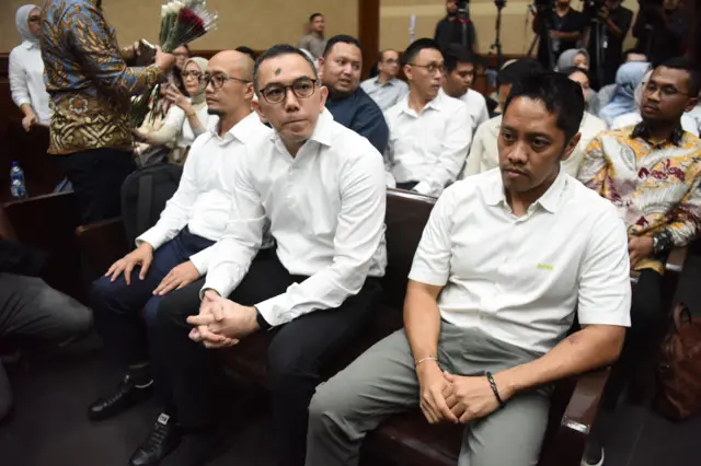 Terdakwa kasus dugaan korupsi tata kelola minyak mentah dan produk kilang pada PT Pertamina Yoki Firnandi (tengah), Agus Purwono (kanan) dan Sani Dinar Saifuddin (kiri) menunggu dimulainya sidang pembacaan putusan di Pengadilan Tipikor, Jakarta, Kamis (26/02).