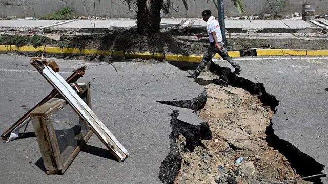 Un hombre camina en una calle agrietada después de un doble terremoto, en Los Corales, estado de La Guaira, a unos 38 km al noroeste de Caracas, el 25 de junio de 2026.