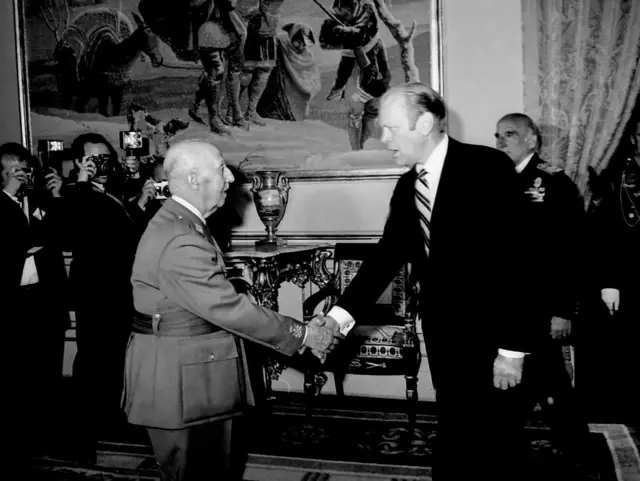 El general Franco, vestido de uniforme, estrecha la mano del presidente Gerald R. Ford, de traje oscuro y corbata de rayas, en una visita del segundo a Madrid en 1973. 