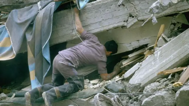 Un hombre busca entre los escombros tras el terremoto de 1985