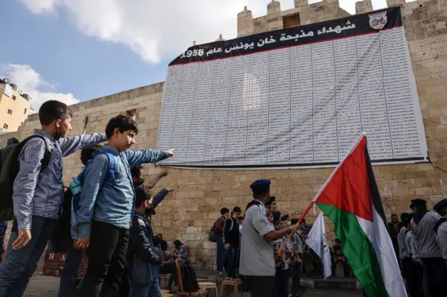 لافتة تحمل أسماء ضحايا مذبحة خان يونس عام 1956 معلقة على جدار قلعة برقوق