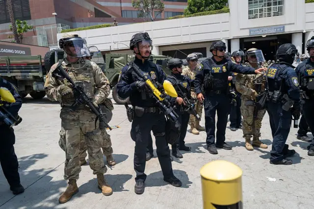 Vệ binh Quốc gia đứng gác cùng với lực lượng LAPD khi những người biểu tình tụ tập bên ngoài Trung tâm giam giữ Metropolitan vào ngày 8/6 Vệ binh Quốc gia đứng gác cùng với lực lượng LAPD khi những người biểu tình tụ tập bên ngoài Trung tâm giam giữ Metropolitan vào ngày 8/6