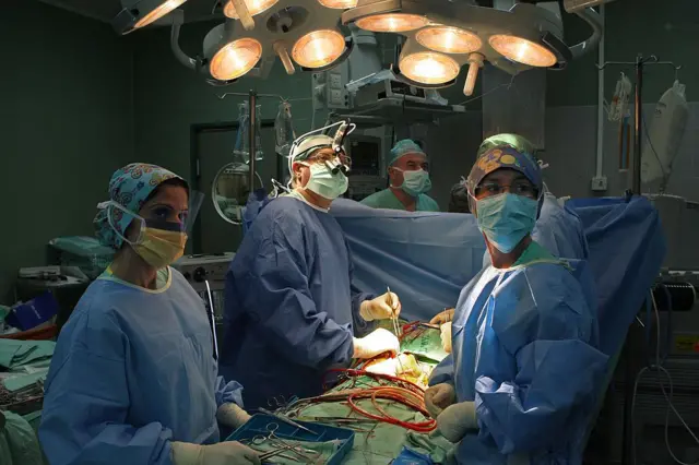 Операция на сердце младенца в Израиле. Хирурги над операционным столом выжидательно смотрят на показания приборов