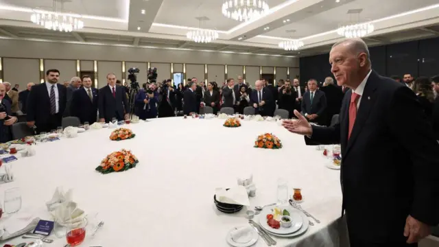 Cumhurbaşkanı Erdoğan yuvarlak bir masada çevredekileri selamlıyor