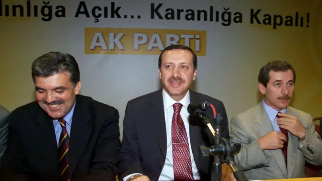 Abdullah Gül, Recep Tayyip Erdoğan ve Abdüllatif Şener yan yana. Ortada bir mikrofon var. Arkada AK Parti'nin amblemi görülüyor. 