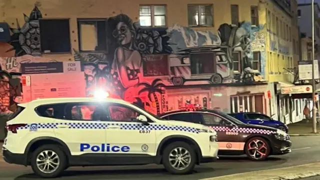 उक्त क्षेत्रमा सुरक्षा व्यवस्था कडा बनाइएको छ। कालो र निलो रङ्गका प्रहरीका गाडीहरू एउटा बजार जस्तो क्षेत्रमा रोकिएको अवस्थामा। 