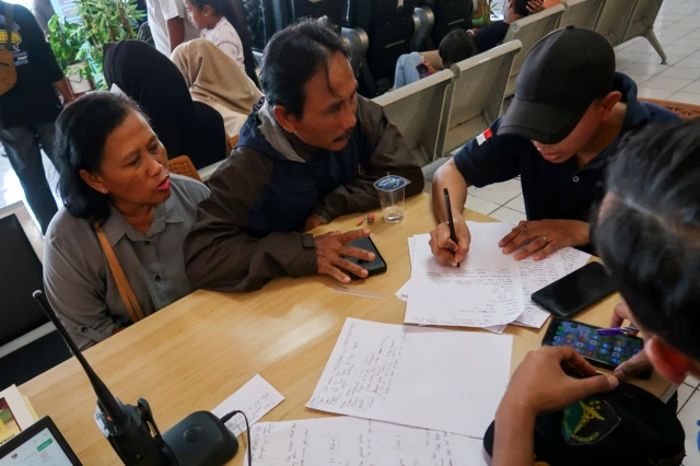 Seorang pria dan perempuan sedang duduk bersama terlihat mereka sedang membuat laporan.
