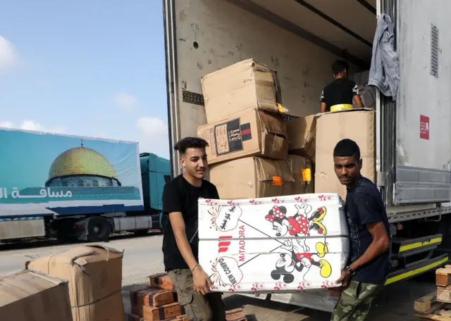 Hombres descargan cargamento humanitario en Gaza este 24 de octubre.