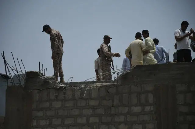 Aparat Pakistan melakukan pemeriksaan setelah terjadi serangan drone India di Karachi, Kamis (08/05).