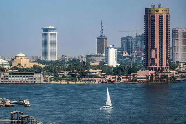Une felouque navigue sur le Nil, au large de l'île de Zamalek, près de l'Opéra du Caire (à gauche), le 6 octobre 2025.