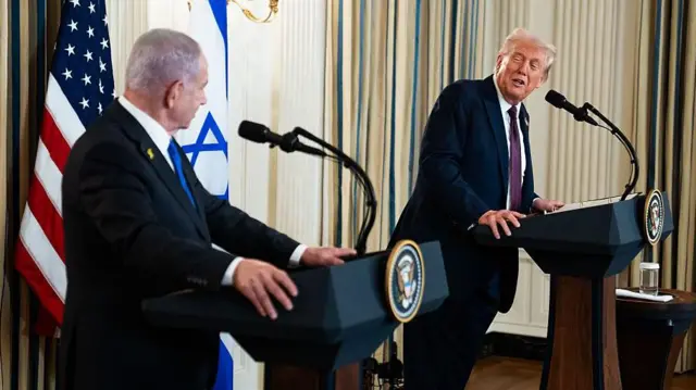 Benjamin Netanyahu y Donald Trump hablan el uno con el otro desde dos atriles en una rueda de prensa en la Casa Blanca. 