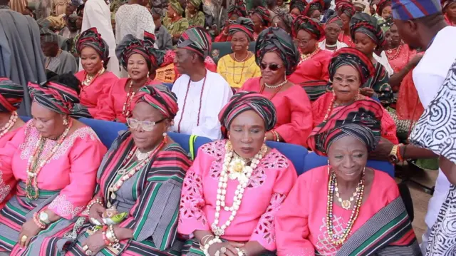 Ẹgbẹ awọn obinrin to wọ asọ oke alaranbara olomi pinki, wọn we gele, wọn si fi ilẹkẹ meji-meji sọrun wọn.