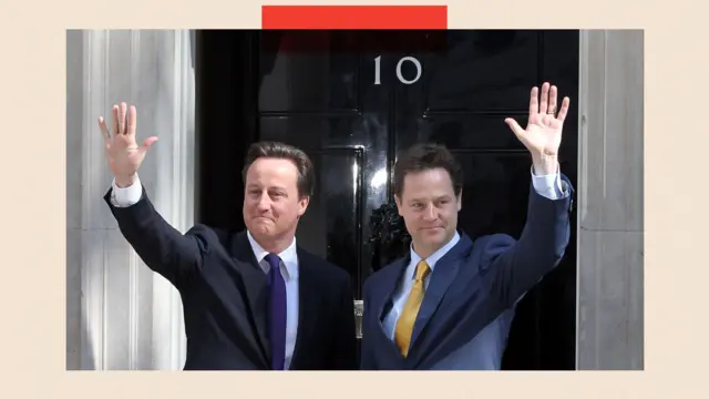 David Cameron (primer ministro) y Nick Clegg (derecha, viceprimer ministro) en Downing Street, saludando.