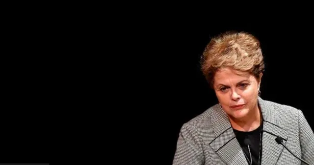 Dilma Rousseffpoker spinfrente a um microfone