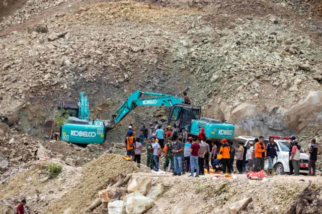 Petugas gabungan dengan alat berat mencari korban longsor yang tertimbun bebatuan di lokasi galian C, Cipanas, Dukuhpuntang, Kab. Cirebon, Jawa Barat, Jumat (30/5/2025). Longsor dari tebing tambang batu tersebut menyebabkan 5 orang meninggal dunia dan puluhan korban lain yang masih belum ditemukan.