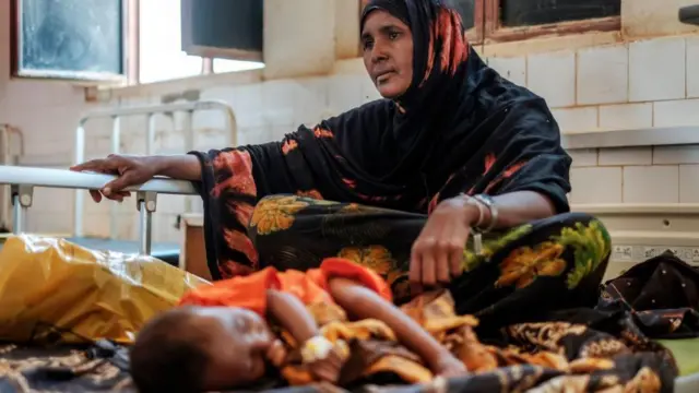 የታመመ ህጻን ጎን ያለች ሴት 