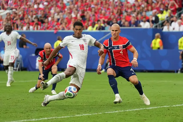 O meio-campista da Inglaterra Jude Bellingham marca um gol enquanto o defensor da Noruega Leo Østigård tenta a defesa, durante a partida das quartas de final da Copa do Mundo, em 11 de julho de 2026.