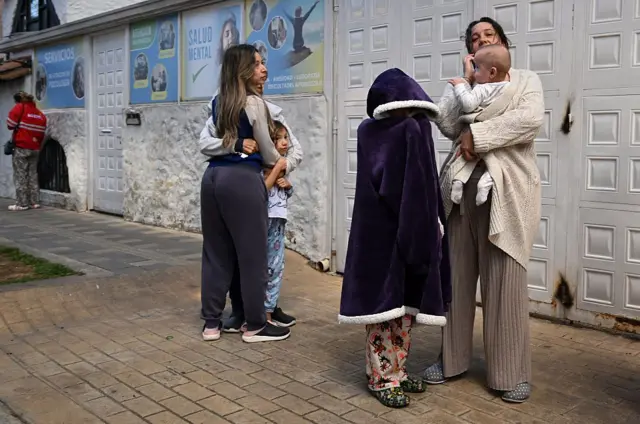 Un grupo de mujeres abrigadas con cobijas frente a una casa tras el terremoto que sacudió a Colombia.