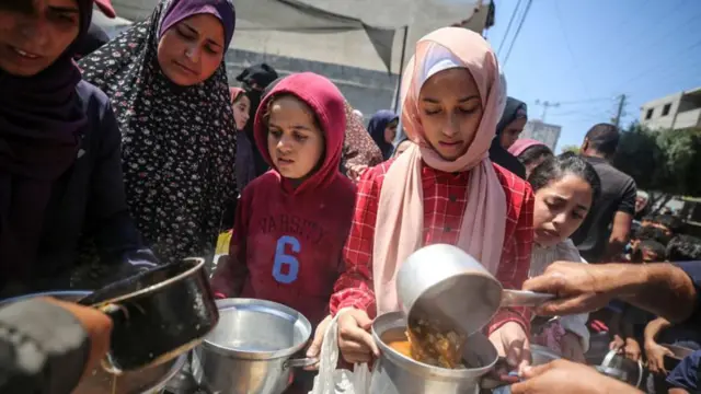 Orang-orang Palestina mengantri makanan di kamp pengungsi Gaza.