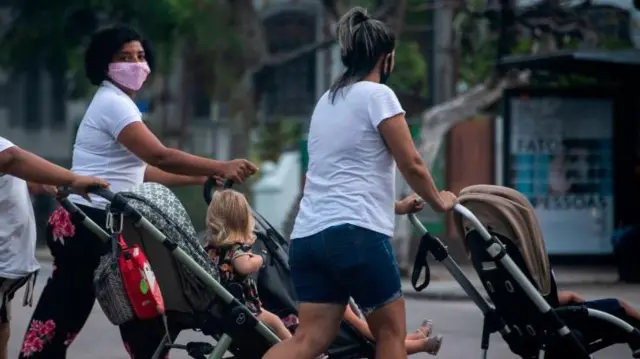 Três babásapostar na betwaycamisa branca empurrando carrinho na rua