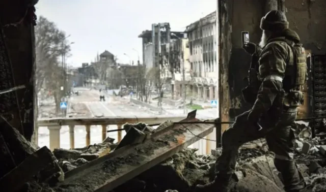 Апрель 2022 года, российский военный стоит на руинах театра в Мариуполе