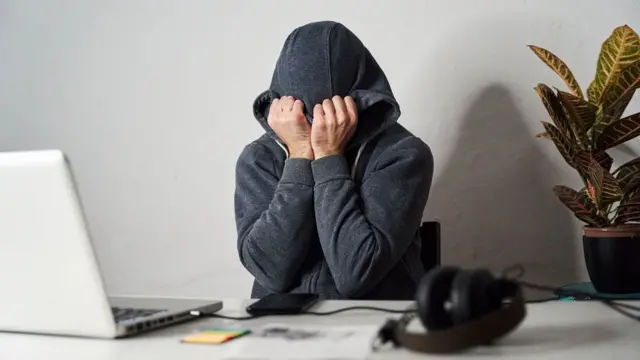 컴퓨터 앞에서 얼굴을 감싸 쥐고 좌절하는 남성