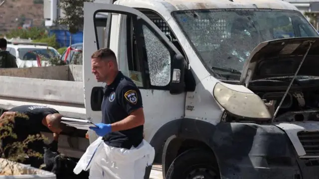 صورة تُظهر خبراء إسرائيليين من الطب الشرعي يقومون بفحص شاحنة استُخدمت في عملية دهس عند نقطة تفتيش