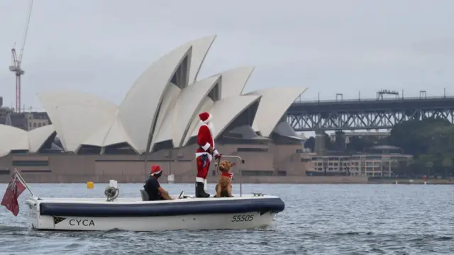 Father Christmas and his dog Rudolph arriving in Sydney Harbour to deliver gifts to the participants of the Rolex Sydney to Hobart yacht race which begins Boxing Day