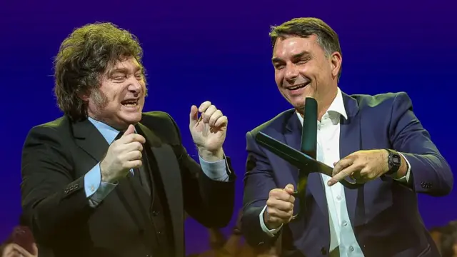 Javier Milei e Flávio Bolsonaro, que segura uma imensa tesoura nas mãos.