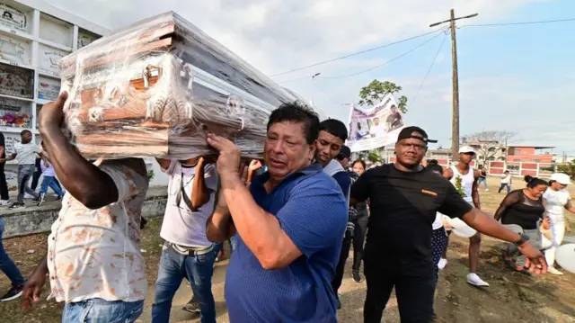 Keluarga dari Josue dan Ismael Arroyo, masing-masing berusia 14 dan 15 tahun,  membawa salah satu peti mati selama pemakaman mereka di pemakaman Angel Maria Canals di Guayaquil, Ekuador, pada 1 Januari 2025.