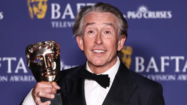 Steve Coogan Bafta ödülünü tutuyor