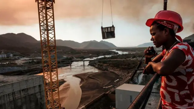 በግድቡ ግንባታ ወቅት የራስ መከላከያ ቆብ አድርጎ የቆ ሠራተኛ