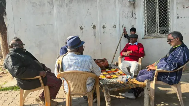 वाल्मिकी मंदिर के पास बैठे मतदाता