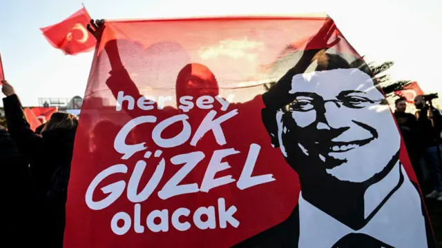 İmamoğlu'nun gözaltına alındığı 19 Mart günü İstanbul Saraçhane'de yapılan gösteride bir kişi üzerinde "Her şey çok güzel olacak" yazan pankart taşıyor. 
