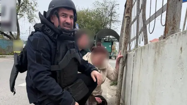Поліцейський і люди ховаються під час атаки російських дронів 